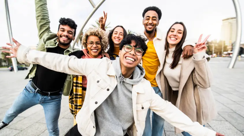 a group of diverse young adults smiling outside